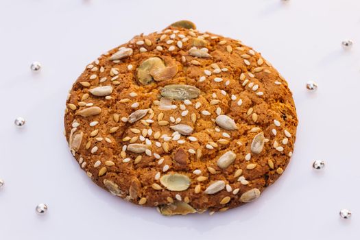 Eat oatmeal cookies. Stack of whole meal cookies on white background. Wheat fall on dietary cookies