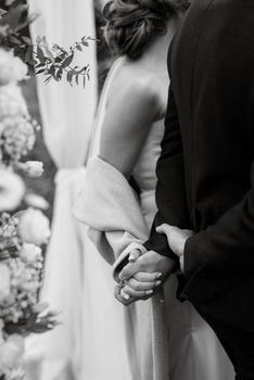 the bride and groom tenderly hold hands between them love and relationships