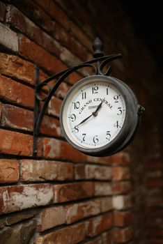 old station clock on a red brick wall