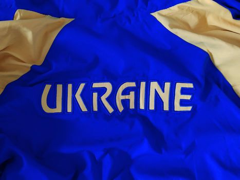 Ukraine is embroidered on a blue-yellow canvas with yellow threads.