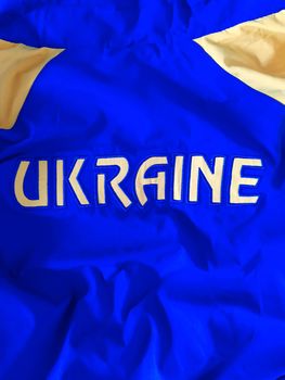 Ukraine is embroidered on a blue-yellow canvas with yellow threads.