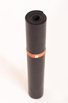 stand black roll yoga mat on white and path