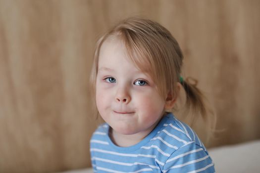 Portrait of child indoors. Happy funny toddler girl at home.