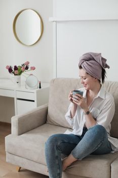 Good morning, smiling young woman drinking coffee in a cozy room at home