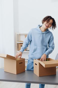 guy with curly hair unpacking with box in hand moving Lifestyle. High quality photo