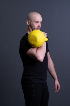 Guy with a yellow kettlebell gym anonymous workout man, in the afternoon sporty teenager from training from up youth, malaysian fitness. Living interval cardio, circuit hiit