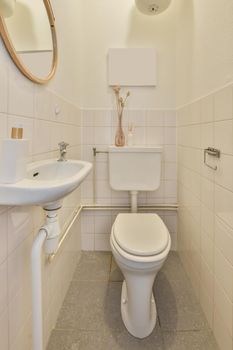 Bathroom interior in white tones with a toilet and ceramic sink under the mirror