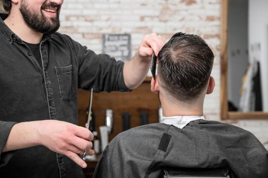 Closeup of happy man getting an haircut, in hair salon. High quality photo.