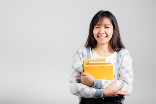 Woman teen smiling holding and hug embrace favorite book for lover, Portrait of beautiful Asian young female person teacher studio shot isolated on white background, education concept