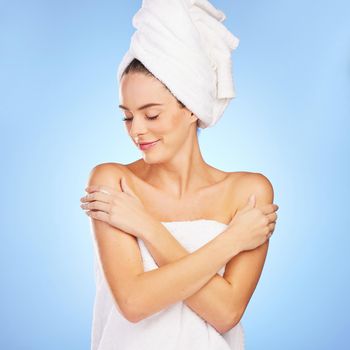 Shot of a young woman in a towel against a blue background.