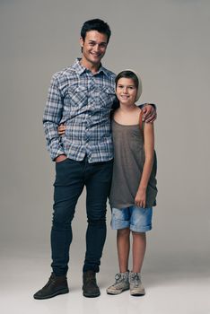 Studio shot of a trendy father and son against a gray background.