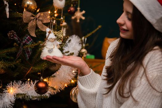 A close-up shot of a young woman who is enchanted by the decoration on the Christmas tree. A tradition in Poland at Christmas time.