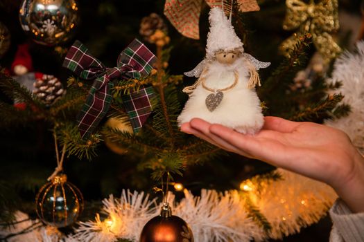 A close-up shot of a young woman who is enchanted by the decoration on the Christmas tree. A tradition in Poland at Christmas time.