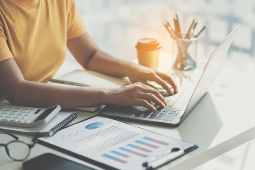 Close up Business woman hand using calculator application on laptop to calculate the company's financial results and budget. Account Audit Concept