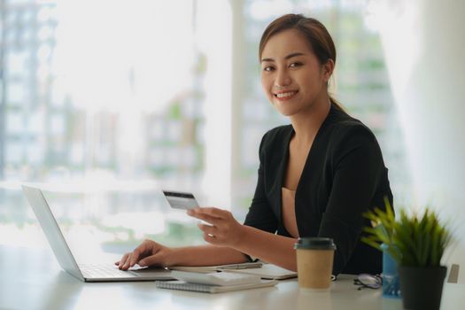 Woman using shopping web site by laptop computer and payment by credit card