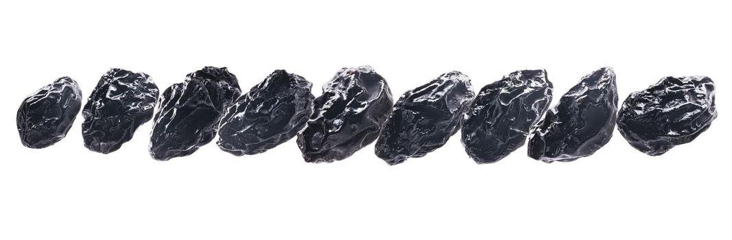 Dried prunes levitate on a white background.