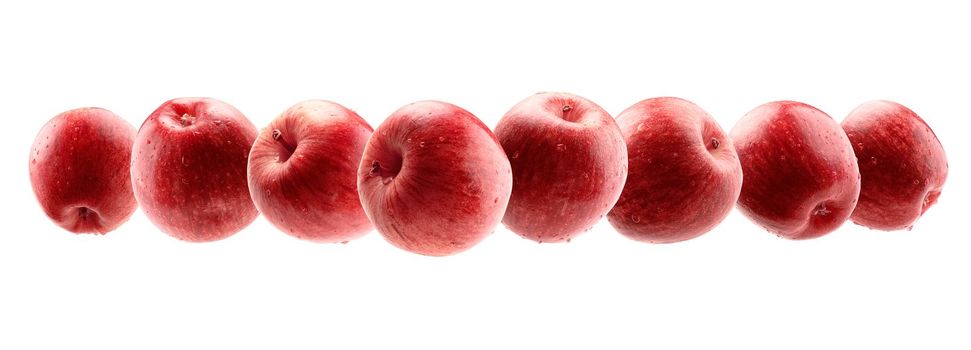 Red apples levitate on a white background.