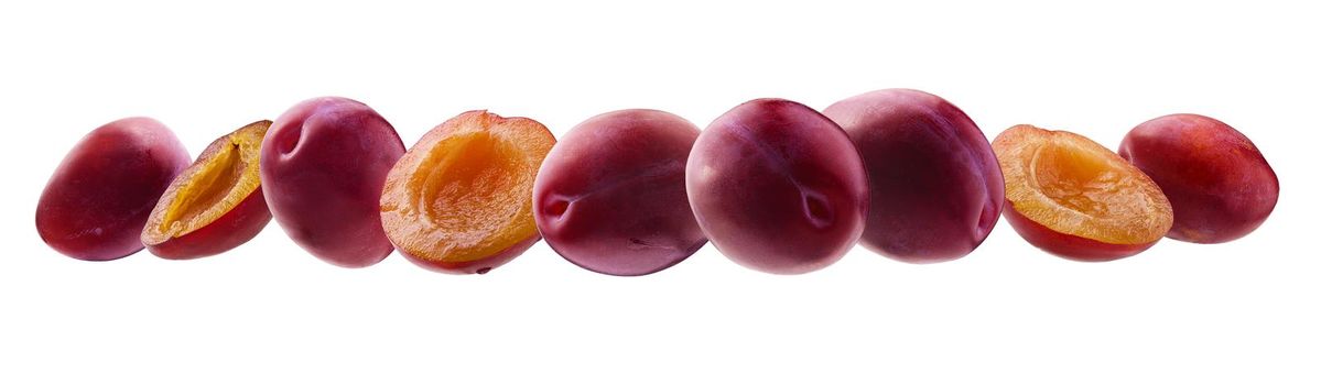 Red plums levitate on a white background.