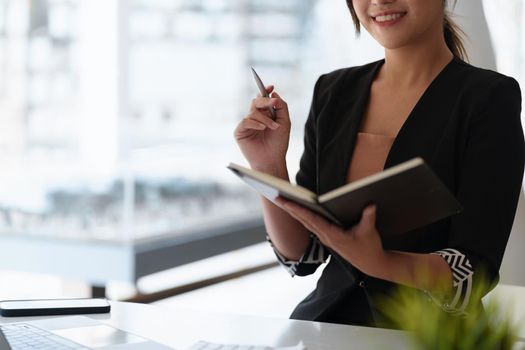 Secretary checking schedule at front of boss room