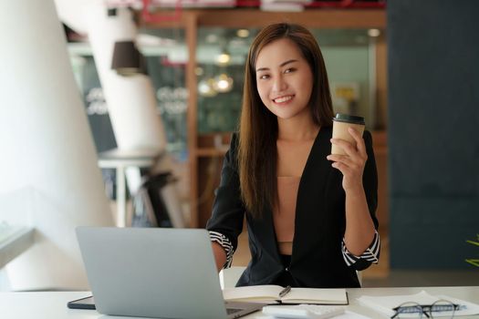 Successful business woman with coffee at office