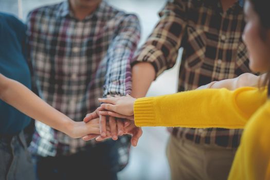 Group of Multiracial people putting their hands working together showing oneness symbol