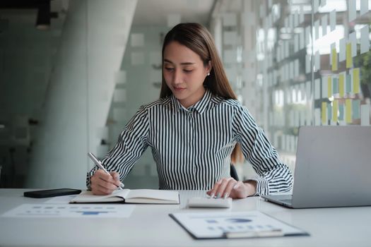 Asian Business woman working to analyze technical price graph and indicator. Account or saving money or insurance concept