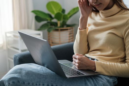 Frustrated stressed woman sitting on sofa at home