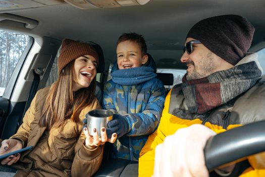 Mother, father and child traveling by car on a vacation to the mountains in winter, close up