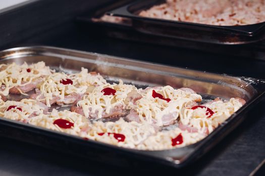 Close up of delicious fresh set meat with cheese on big metallic dish standing on kitchen, looking mouthwatering and tasty. Preparing for fire and cooking raw meat.