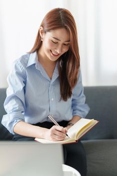 Beautiful Asian Business woman watching educational webinar on laptop computer. Finance concept