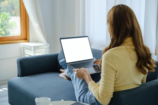 Woman enjoy with content streaming movies or social media application on laptop computer sitting on sofa at home