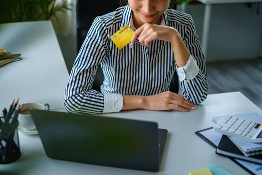 Woman using shopping web site by laptop computer and payment by credit card