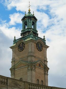 Vertical view of the bell tower of the Cathedral of St. Nicholas Storkyrkan at twelve o'clock. Stockholm, Sweden