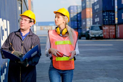Technician or workers man and woman discuss about the product in cargo container shipping area with day light.