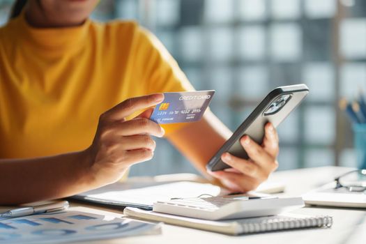 Woman using shopping application by smartphone and payment by credit card