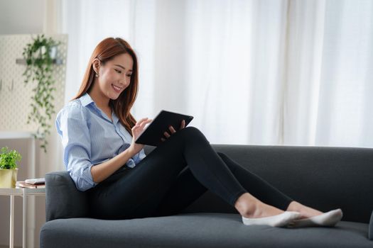 Beautiful Asian Business woman watching educational webinar on digital tablet. Finance concept