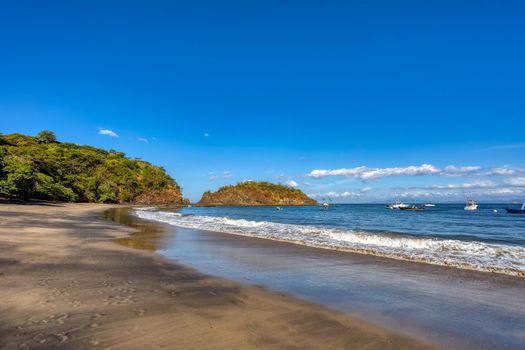 Playa Ocotal with Pacific ocean waves on rocky shore, El Coco Costa Rica. Famous snorkel beach. Picturesque paradise tropical landscape. Pura Vida concept, travel to exotic tropical country.