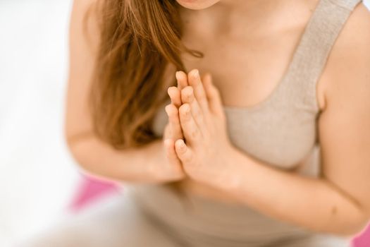 Girl does yoga. Young woman practices asanas on a beige one-ton background