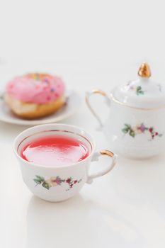 morning breakfast with colorful pink drink and donuts on white table. holiday, birthday party composition, flatlay top view. 