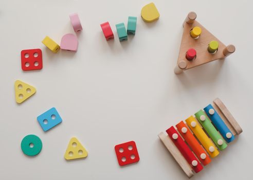 Top view colorful eco-friendly non-plastic wooden toys on white table. Early learning and development.