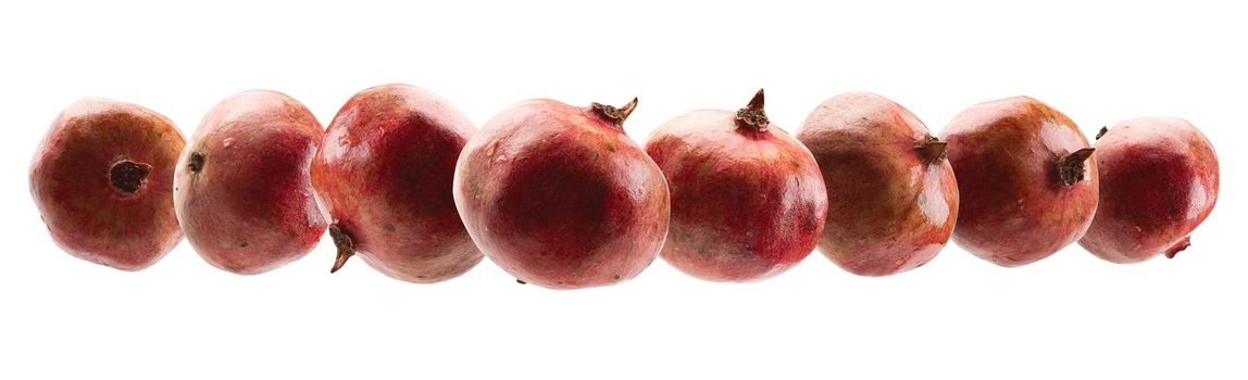 Ripe pomegranates levitate on a white background.