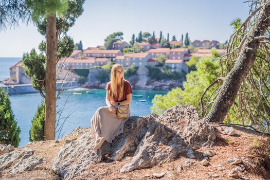 Woman tourist on background of beautiful view of the island of St. Stephen, Sveti Stefan on the Budva Riviera, Budva, Montenegro. Travel to Montenegro concept.