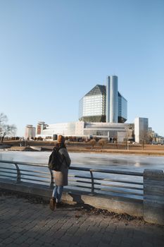 A tourist woman enjoys the view of cityscape of National library in Minsk, Belarus, during spring time.