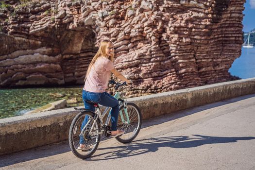 Woman tourist on a bicycle explores Budva in Montenegro. Cycling in Montenegro concept.