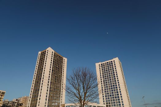 The urban landscape of large city. Exteriors of typical modern apartment buildings against a blue sky with clouds