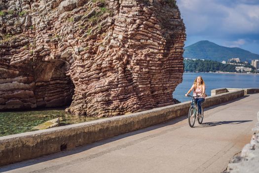 Woman tourist on a bicycle explores Budva in Montenegro. Cycling in Montenegro concept.