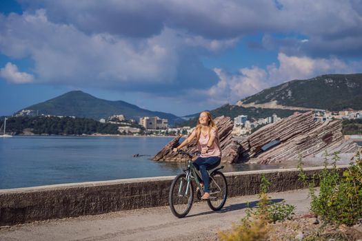 Woman tourist on a bicycle explores Budva in Montenegro. Cycling in Montenegro concept.