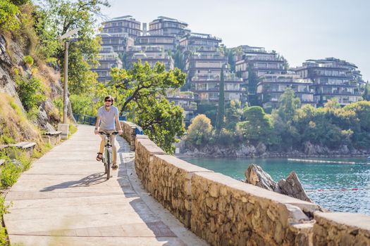 Man tourist on a bicycle explores Budva in Montenegro. Cycling in Montenegro concept.