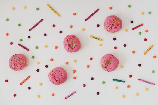 holiday, birthday party composition with colorful pink glazed donuts on white. 