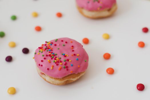 holiday, birthday party composition with colorful pink glazed donuts on white. 